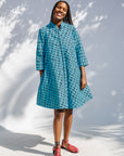 Model wearing blue and black squiggle print dress.