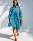 Model wearing blue and black squiggle print dress.