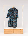 Display of black dress with blue and beige floral print.