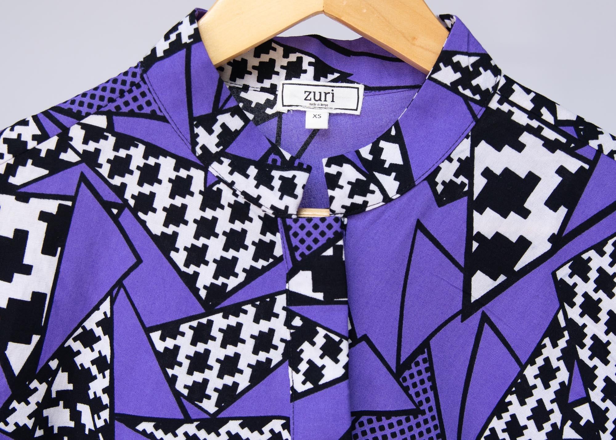Display of purple, black and white geometric print dress