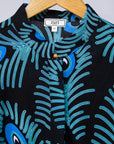 Display of black dress with blue, white and turquoise peacock feather design print