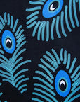 Close up display of black dress with blue, white and turquoise peacock feather design print