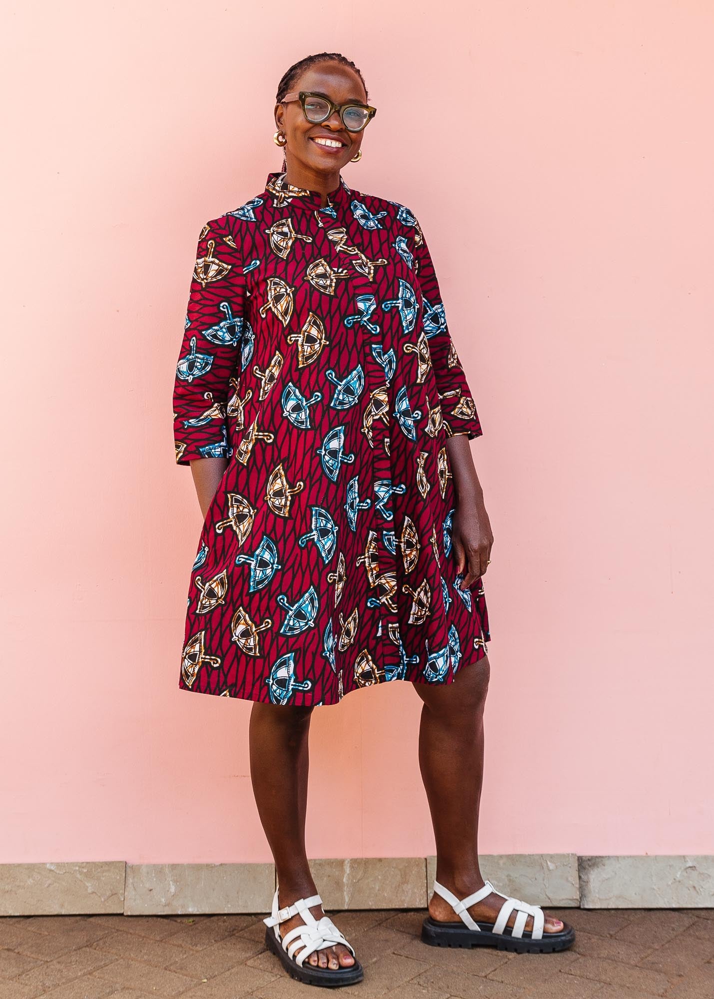 The model is wearing red and black dress with umbrella design print