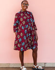 The model is wearing red and black dress with umbrella design print