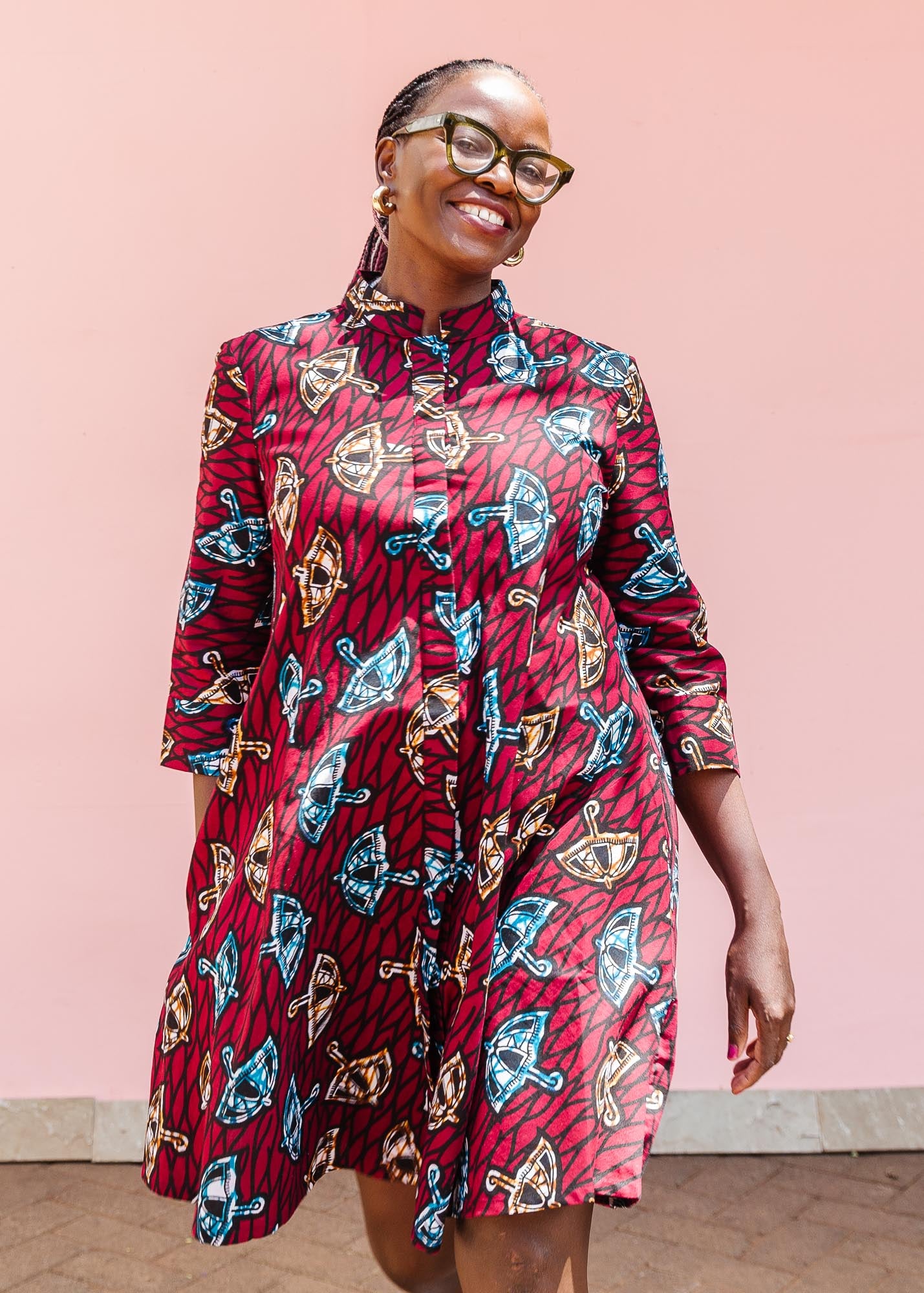 The model is wearing red and black dress with umbrella design print