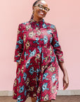 The model is wearing red and black dress with umbrella design print