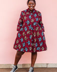 The model is wearing red and black dress with umbrella design print
