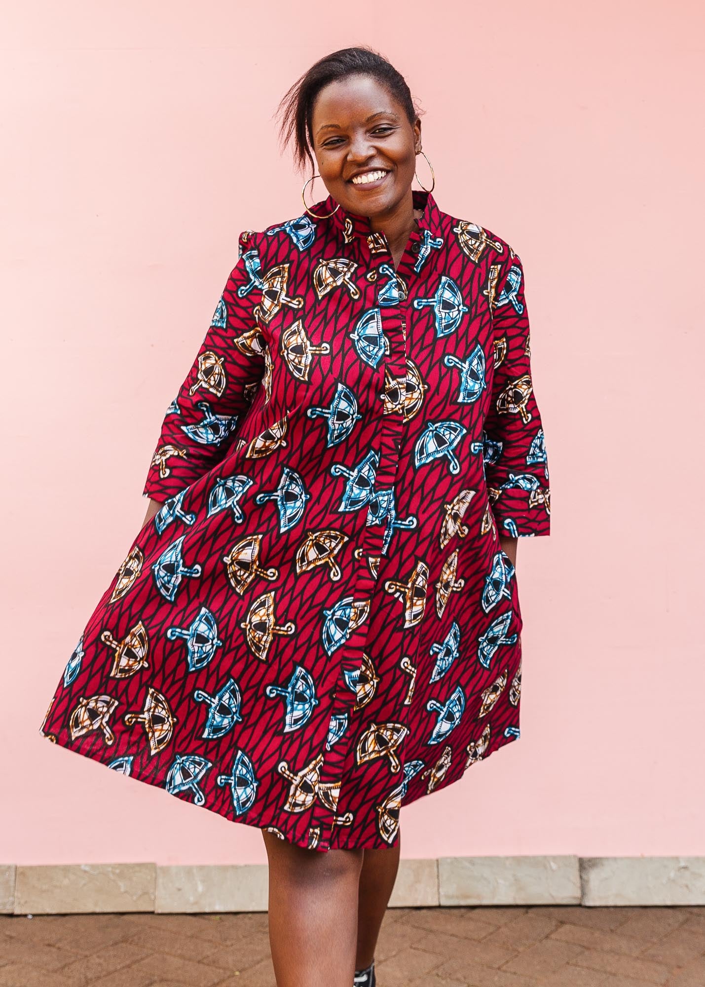 The model is wearing red and black dress with umbrella design print