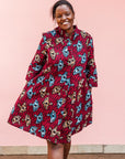 The model is wearing red and black dress with umbrella design print