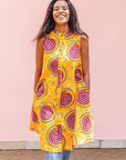 The model is wearing orange white, black and burgundy snail design dress