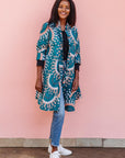 The model is wearing teal, white, black and peach dress with gears