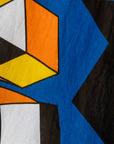 Close up display of blue, black, orange, yellow, orange and white geometric print shirt and culotte, fabric.