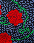 Close up Display of gray and black dress with yellow and red rose print, fabric.