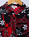 Display of black dress with red and white flowers.