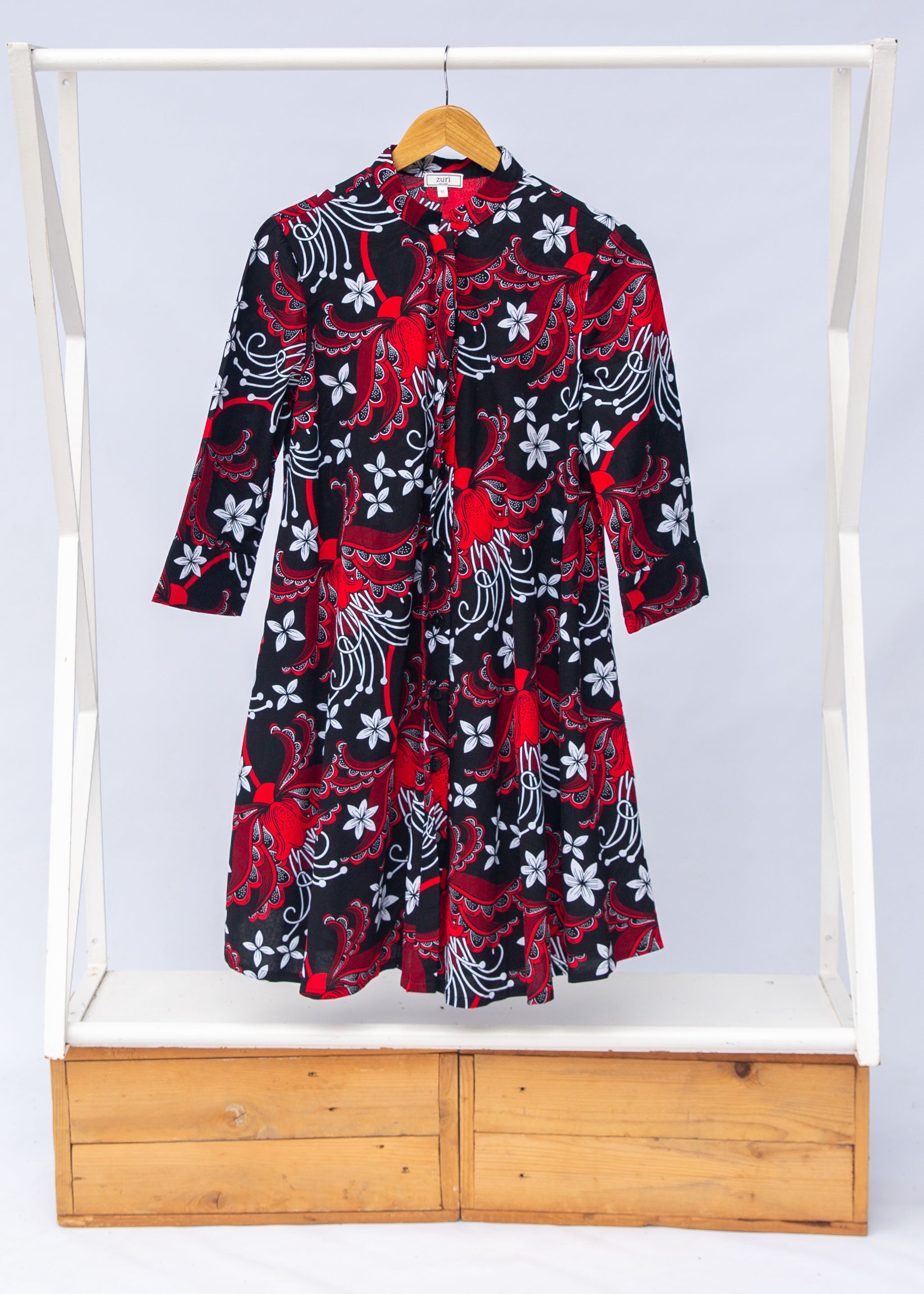 Display of black dress with red and white flowers.