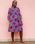 Model wearing purple dress with black and white puzzle print.