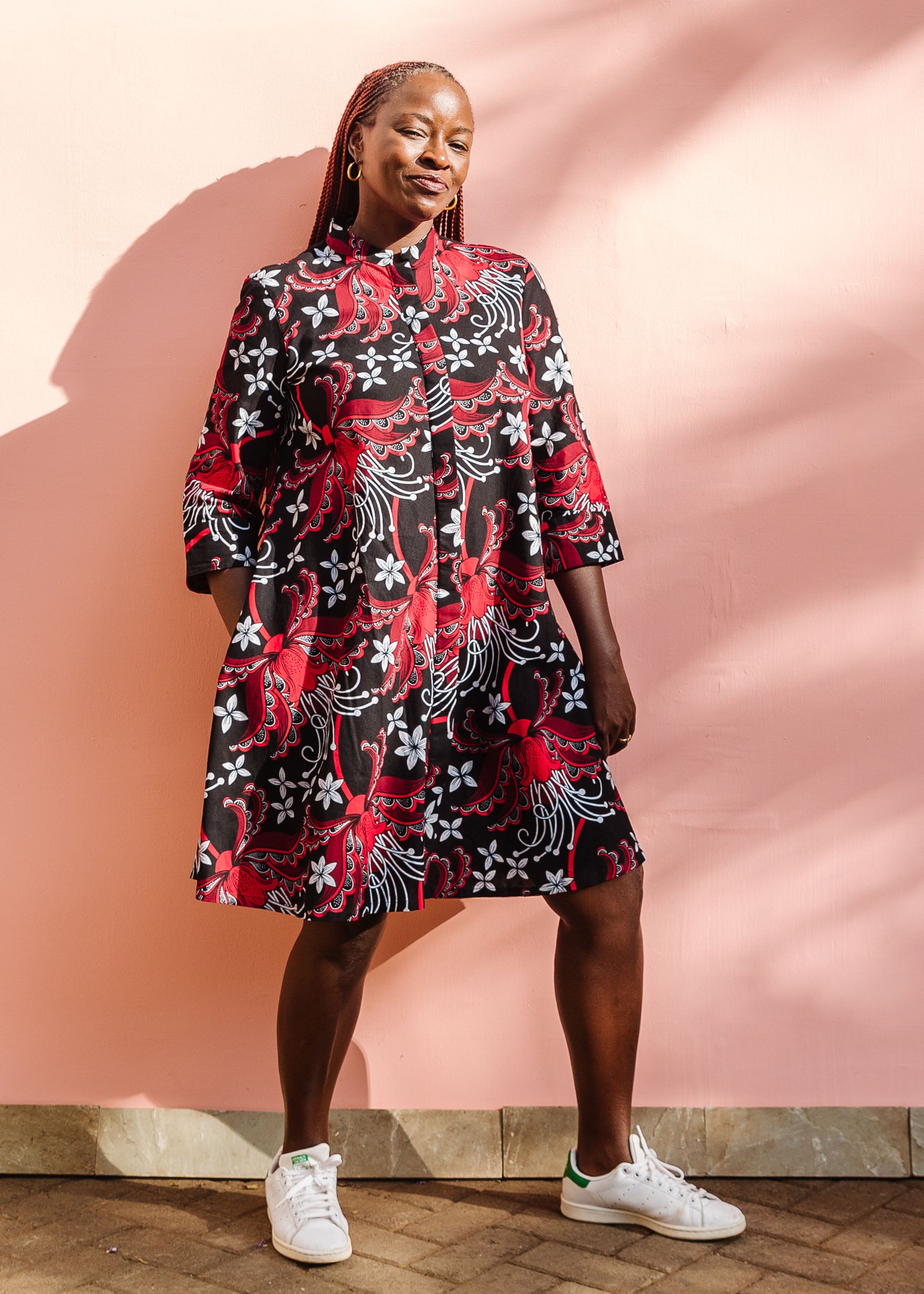 Model wearing black dress with red and white flowers.