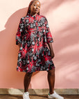 Model wearing black dress with red and white flowers.