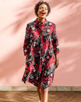 Model wearing black dress with red and white flowers.