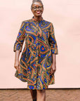 The model is wearing blue, red, black, yellow and white ornamental print dress
