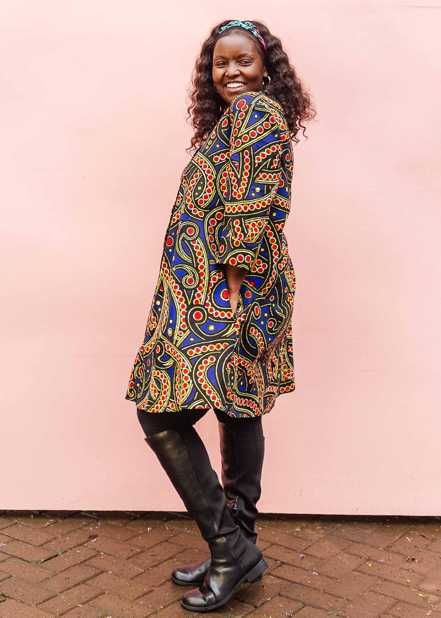 The model is wearing blue, red, black, yellow and white ornamental print dress