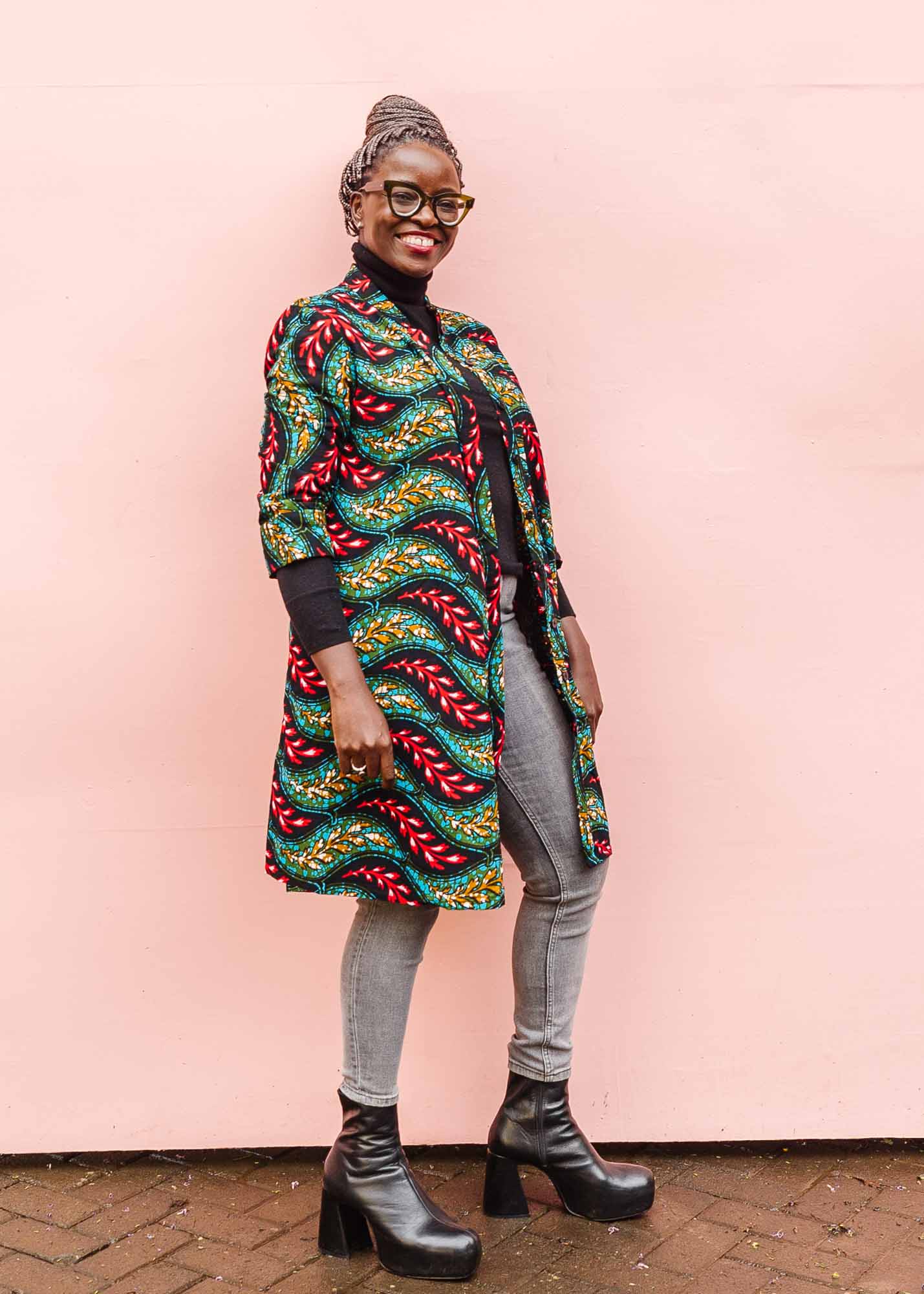 The model is wearing multicolored leaf print dress