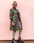 The model is wearing multicolored leaf print dress