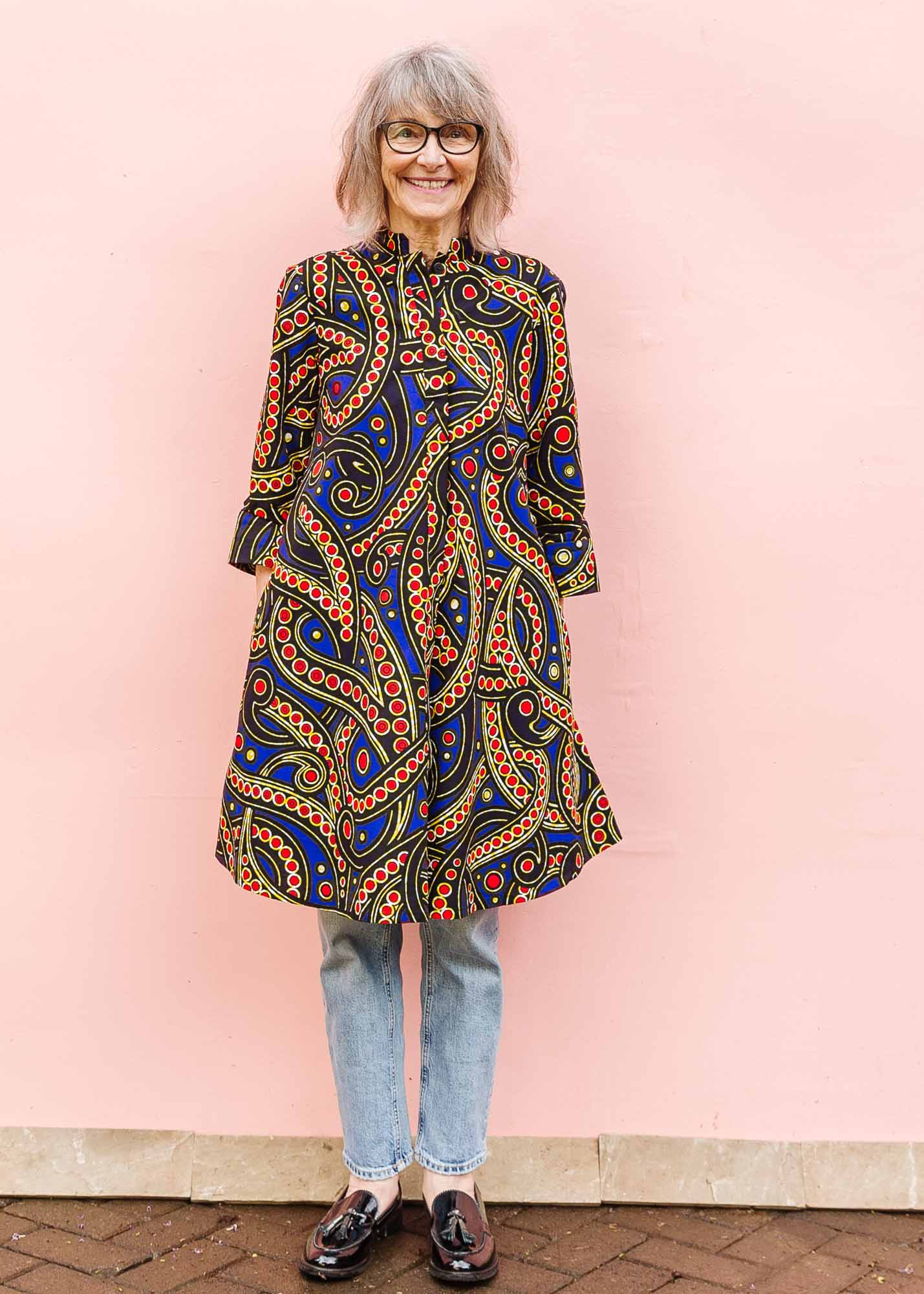 The model is wearing blue, red, black, yellow and white ornamental print dress
