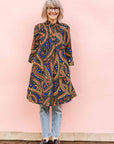 The model is wearing blue, red, black, yellow and white ornamental print dress