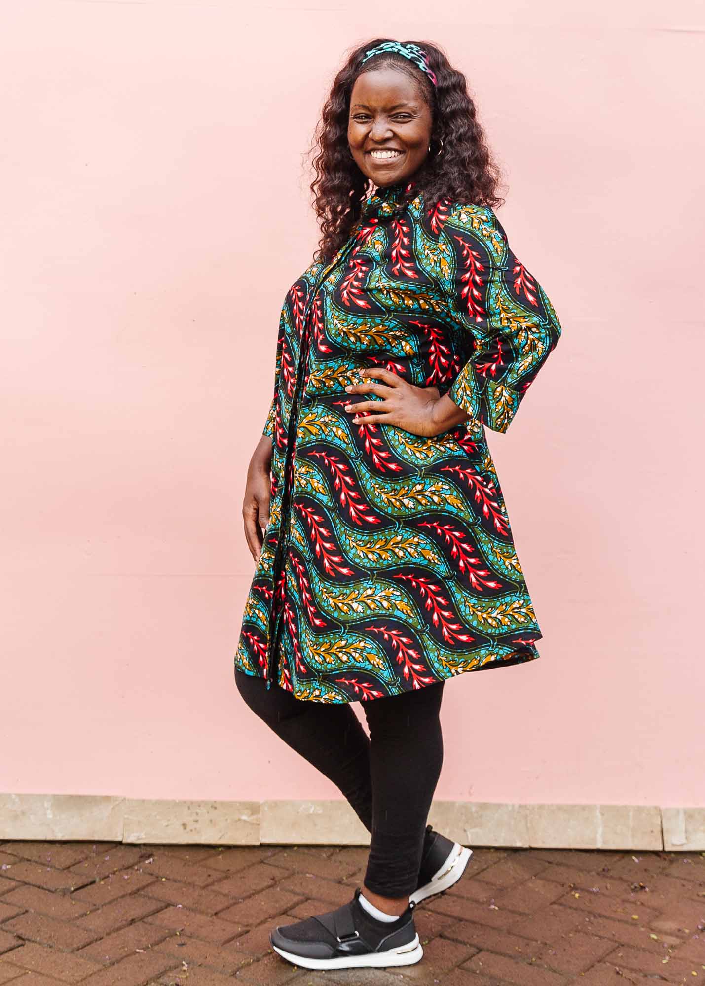 The model is wearing multicolored leaf print dress