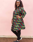 The model is wearing multicolored leaf print dress