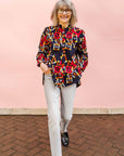 The model is wearing navy shirt with red, orange, yellow and white geometric print