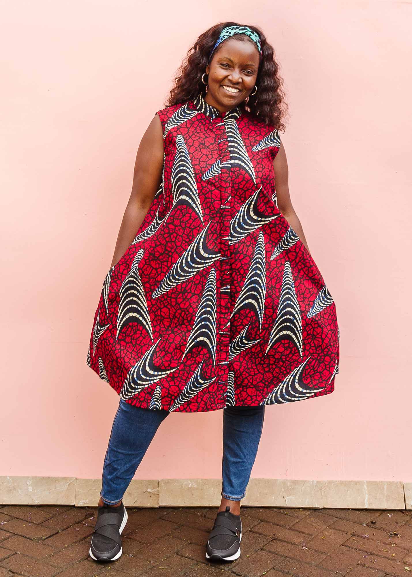 The model is wearing red and black dress with navy blue and beige print