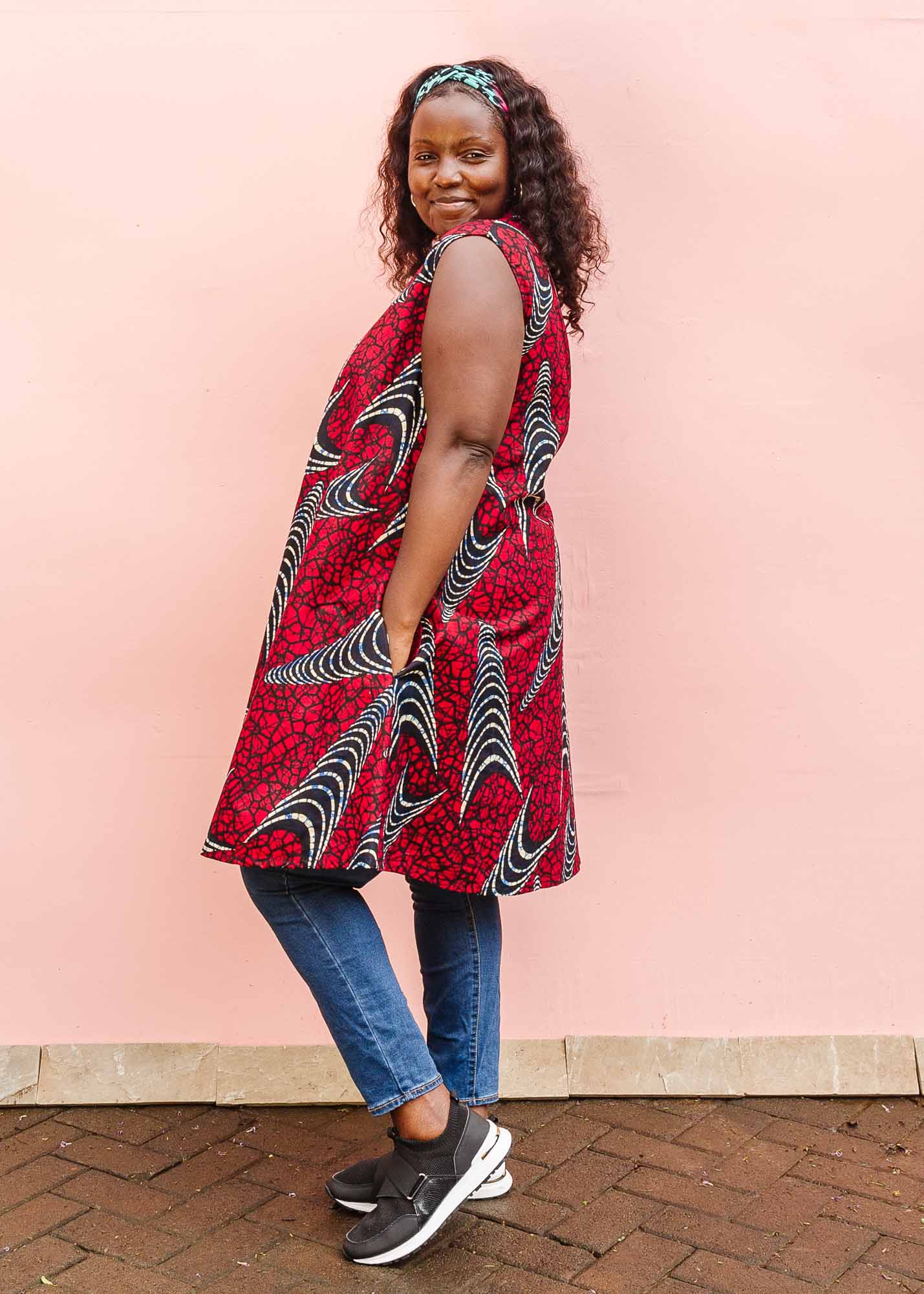 The model is wearing red and black dress with navy blue and beige print