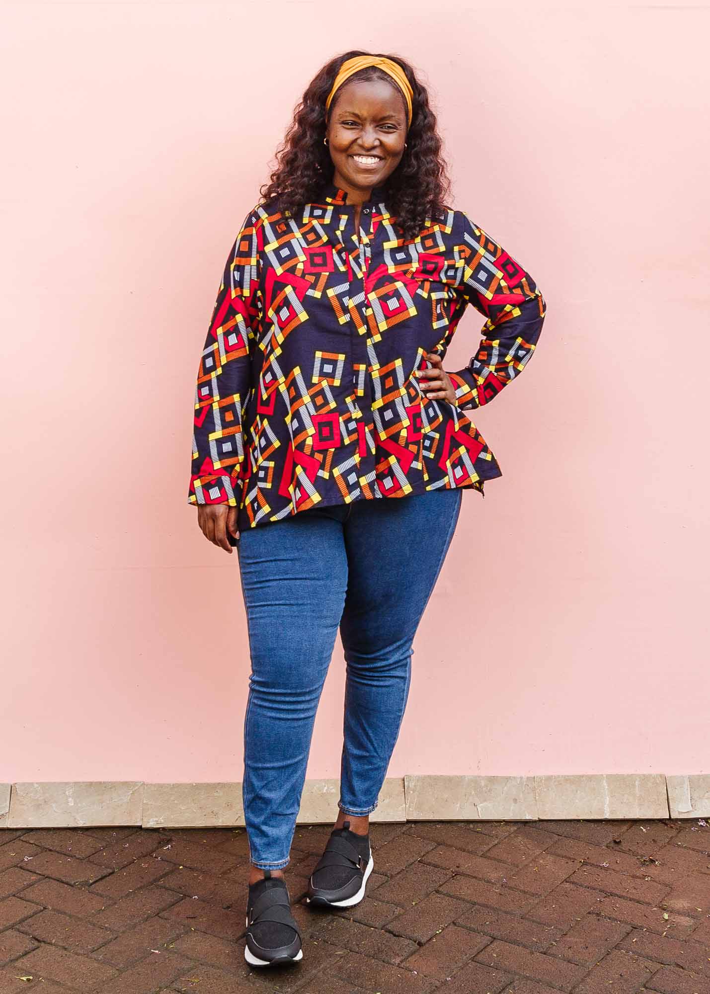 The model is wearing navy shirt with red, orange, yellow and white geometric print