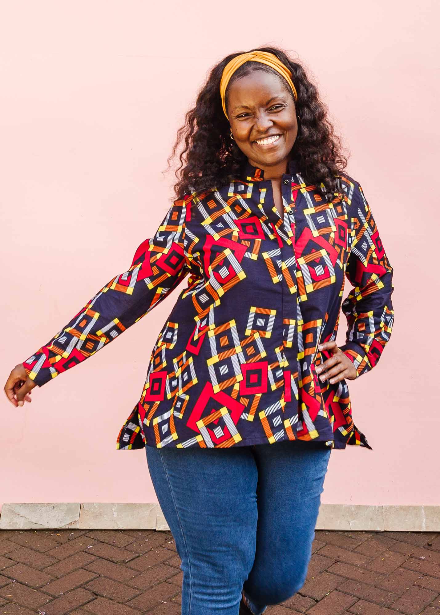 The model is wearing navy shirt with red, orange, yellow and white geometric print