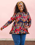 The model is wearing navy shirt with red, orange, yellow and white geometric print
