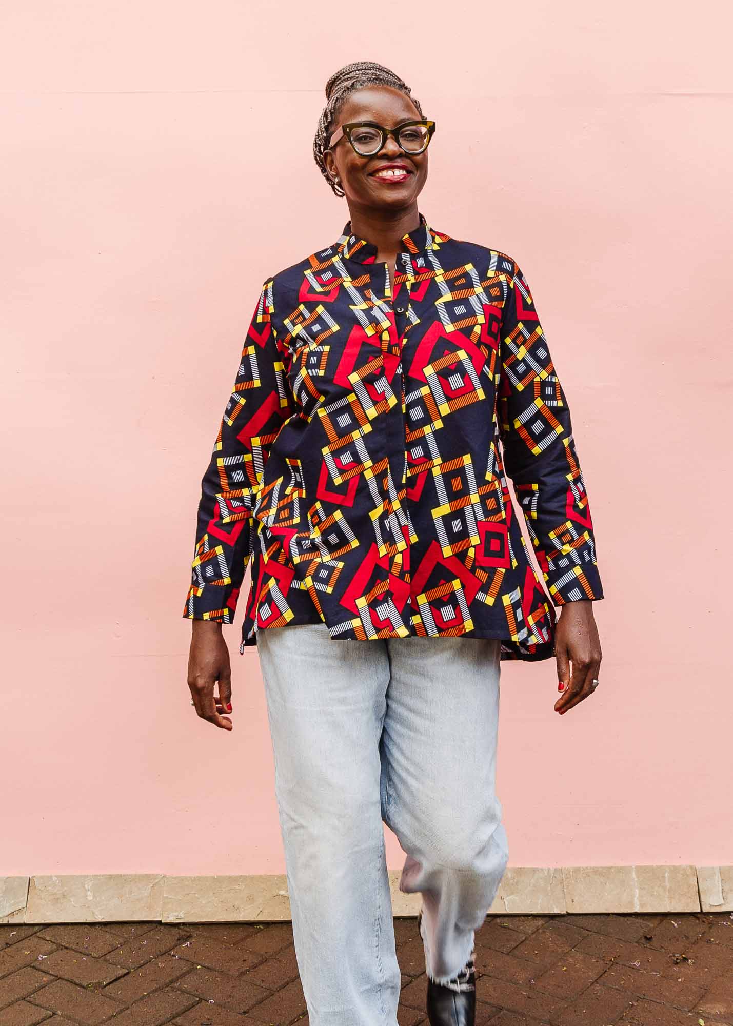 The model is wearing navy shirt with red, orange, yellow and white geometric print