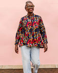 The model is wearing navy shirt with red, orange, yellow and white geometric print