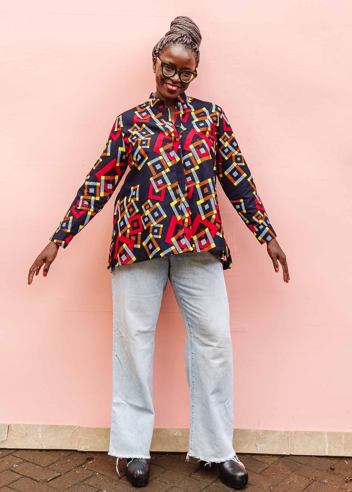 The model is wearing navy shirt with red, orange, yellow and white geometric print