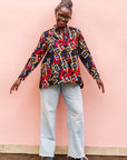 The model is wearing navy shirt with red, orange, yellow and white geometric print