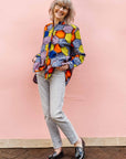 The model is wearing multicolored long sleeved shirt with geometric print