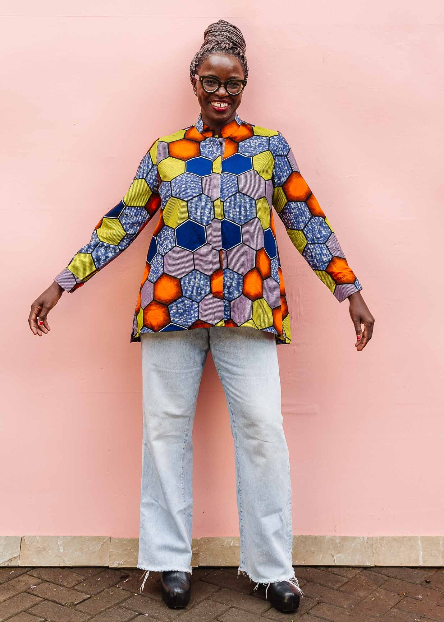 The model is wearing multicolored long sleeved shirt with geometric print