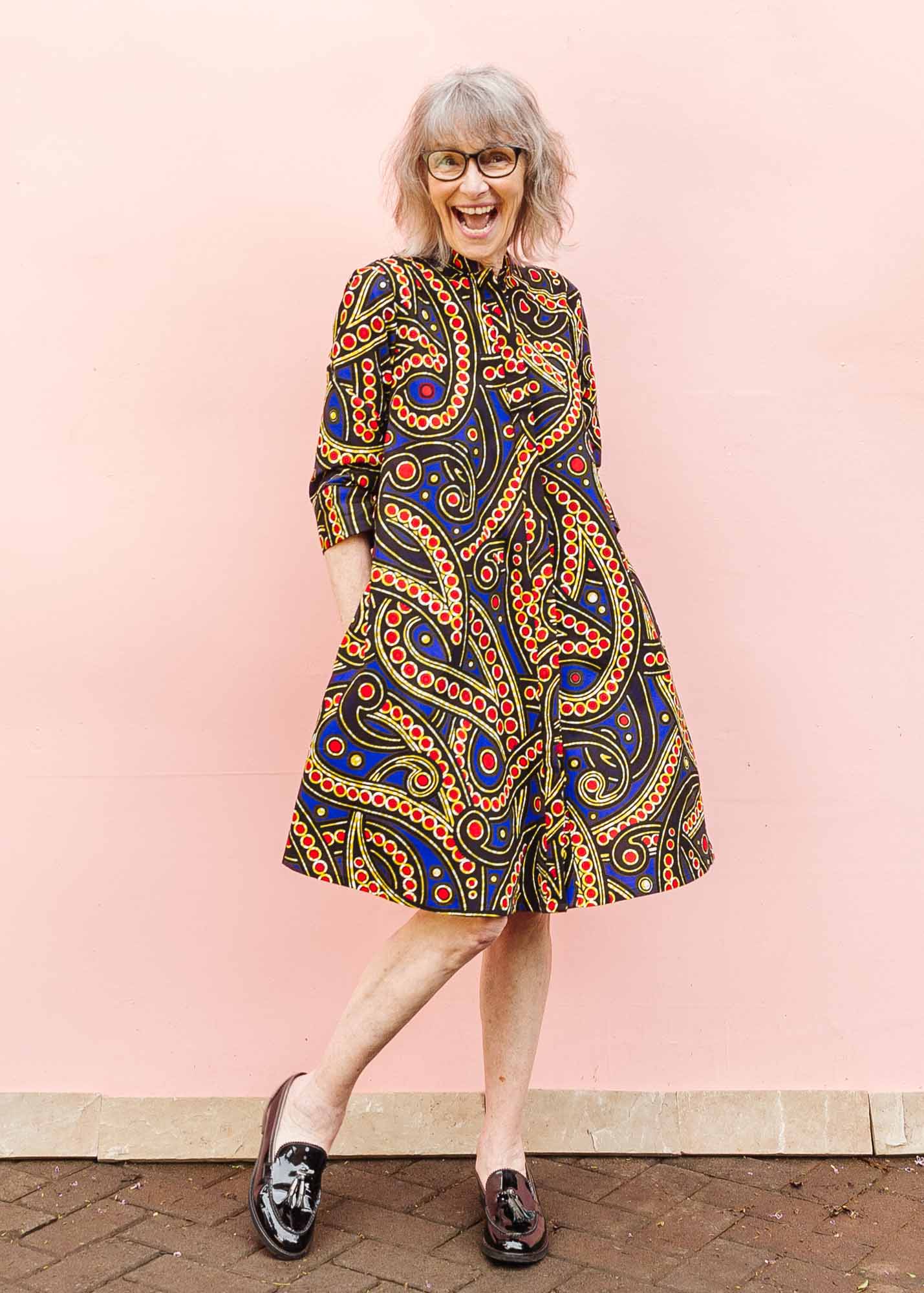 The model is wearing blue, red, black, yellow and white ornamental print dress