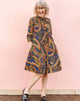 The model is wearing blue, red, black, yellow and white ornamental print dress