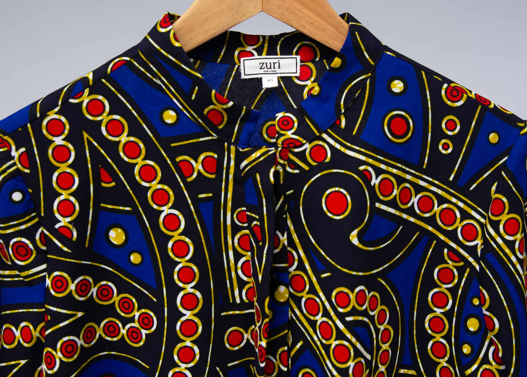 The display blue, red, black, yellow and white ornamental print dress