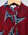 The display of red and black dress with navy blue and beige print