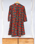 Display of grey dress with red, yellow and black leaf print
