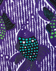 Close up display of long sleeved shirt with purple and green fish print, fabric.