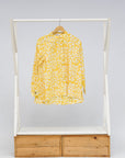 Display of yellow long sleeve shirt with white leaf print.